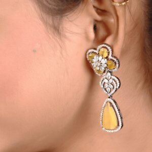 The girl wears a mustard colored American diamond earring for one ear