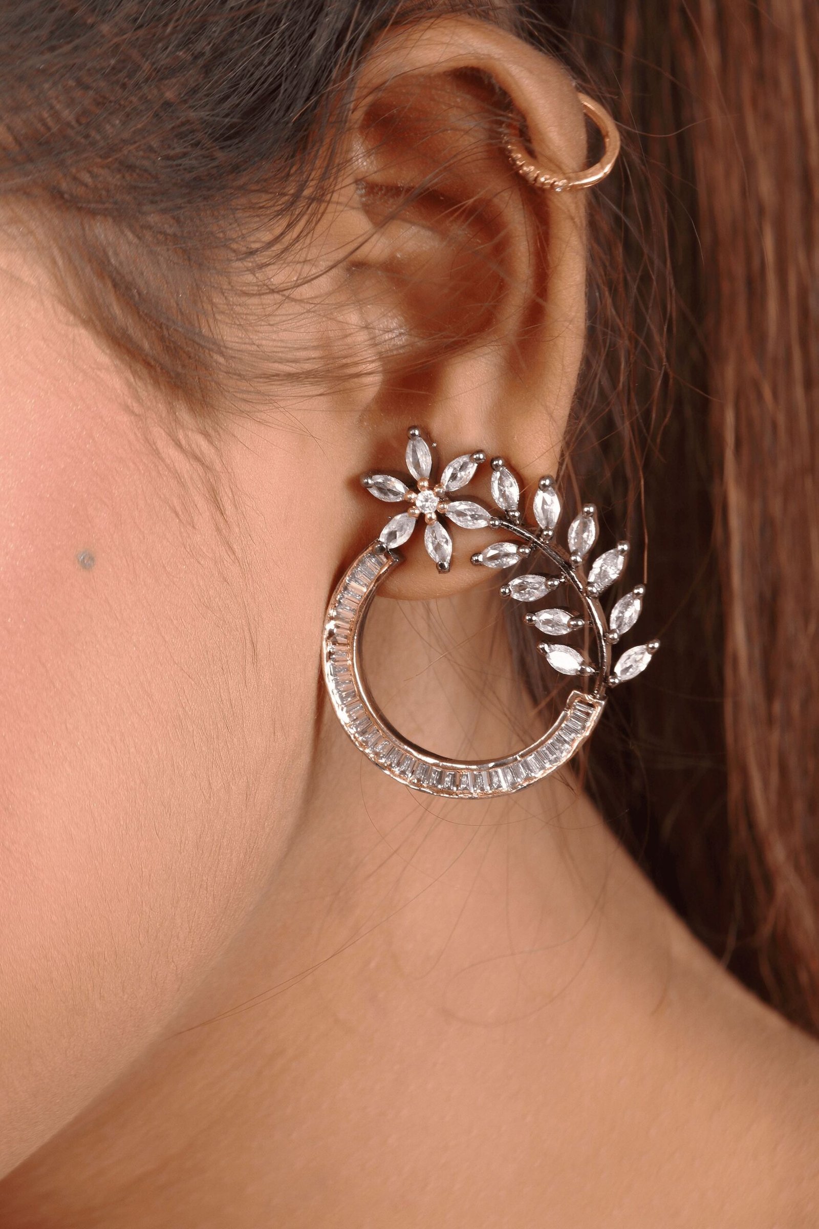 The woman is wearing an American diamond stud earrings in her left ear